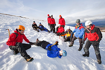 A group of mountaineers practise ice axe arrests on Cairngorm in the Cairngorm National Park in Scotland, United Kingdom, Europe