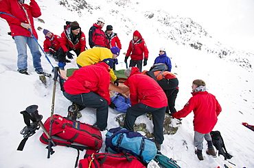 Mountain rescue team members rescue a seriously injured women from Red Screes who had fallen 300 feet in the snow, Lake District, Cumbria, England, United Kingdom, Europe