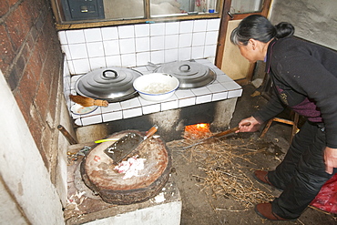 A traditional kitchen stove fuelled mainly by dried mazie stalks, also heats the sleeping platforms in the two roomed peasant farmer's house in northern China, Asia