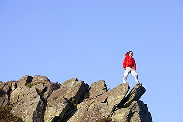 A climber on a boulder above Chapel Stile in the Langdale Valley in the Lake District, Cumbria, England, United Kingdom, Europe