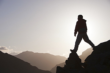 A climber on a ridge above Chapel Stile in the Langdale Valley in the Lake District, Cumbria, England, United Kingdom, Europe