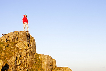 A climber on a boulder above Chapel Stile in the Langdale Valley in the Lake District, Cumbria, England, United Kingdom, Europe