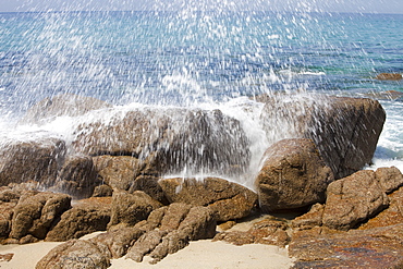 Wave crashing spray over a rock on Porth Nanven beach, Cornwall, England, United Kingdom, Europe