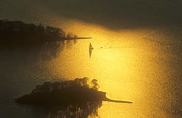 A sailing boat on Derwent Water at sunset in the Lake District National Park, Cumbria, England, United Kingdom, Europe