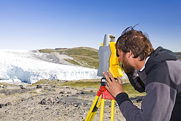 PHD scientist Ian Bartholomew using a theodolite to measure the speed of the Russell Glacier near Kangerlussuaq, Greenland, Polar Regions