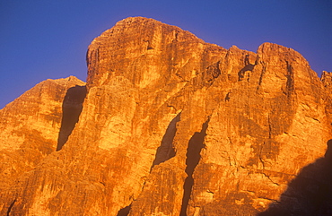 A limestone cliff glowing in dawn light in the Italian Dolomites, Italy, Europe