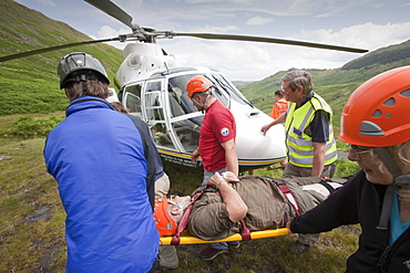 Paramedics from the Great North Air Ambulance and members of Langdale/Ambleside Mountain Rescue Team treat an injured man who fell into Wrynose Beck, before transferring him to hospital via helicopter. Lake District, Cumbria, England, United Kingdom, Europe