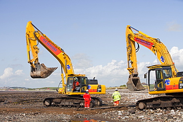 Construction workers working on the foreshore of the Solway Firth near Workington, Cumbria, England, United Kingdom, Europe