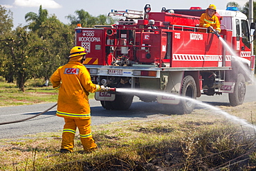 CFA fire fighters tackle a roadside fire probably started by a motorist throwing a cigarette out of the window, near Shepperton, Victoria, Australia, Pacific