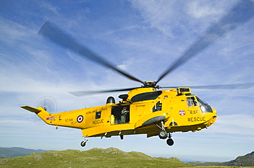 RAF Sea King Helicopter about to land on Crinkle Crags to evacuate an injured walker being treated by a mountain rescue team, Lake District, Cumbria, England, United Kingdom, Europe