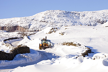 Charlie Middleton, an employee of Cumbria County Council clears snow from the blocked Kirkstone Pass, the highest mountain pass in the Lake District, Cumbria, England, United Kingdom, Europe