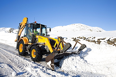 Charlie Middleton, an employee of Cumbria County Council clears snow from the blocked Kirkstone Pass, the highest mountain pass in the Lake District, Cumbria, England, United Kingdom, Europe