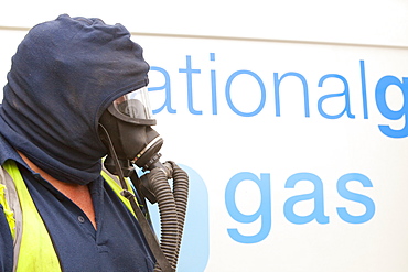 A Britiush Gas worker wears protective gas mask prior to cutting through the gas main as part of an upgrade of piping, Ambleside, Cumbria, England, United Kingdom, Europe