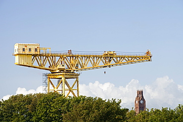 A crane in the shipyards of Barrow in Furness with Barrow Town Hall behind, Cumbria, England, United Kingdom, Europe