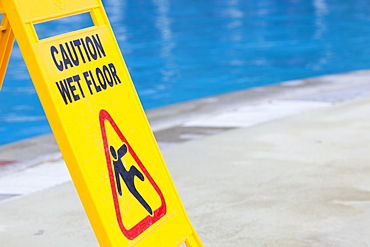 A caution sign on the edge of a swimming pool