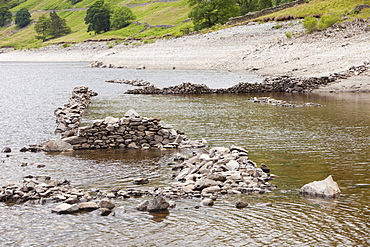 Low water level reveals old walls of Mardale village that was flooded when Haweswater reservoir was created, Lake District, Cumbria, England, United Kingdom, Europe