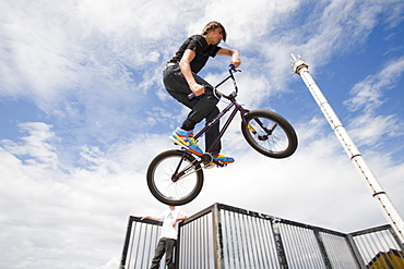 Teenage boys perform aerial stunts on BMX bikes at a BMX park in Rhyl, North Wales, United Kingdom, Europe