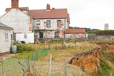 Houses that have already lost gardens to the sea on one of the most rapidly eroding coastlines in the British Isles, Happisburgh, North Norfolk, England, United Kingdom, Europe