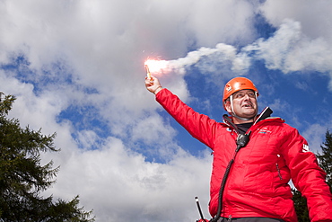 A member of Langdale/Ambleside Mountain Rescue Team uses a flare to attract an incoming Sea King helicopter to a casualty site, Grasmere, Lake District, Cumbria, England, United Kingdom, Europe