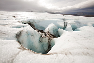 Meltwater on the Langjokull ice cap in Iceland disappearing into a moulin, Iceland, Polar Regions