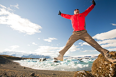 A tourist at Jokulsarlon ice lagoon, one of the most visited places in Iceland, Polar Regions