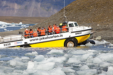 An amphibious vehicle taking tourists on a trip at the Jokulsarlon ice lagoon which is one of the most visited places in Iceland, Polar Regions