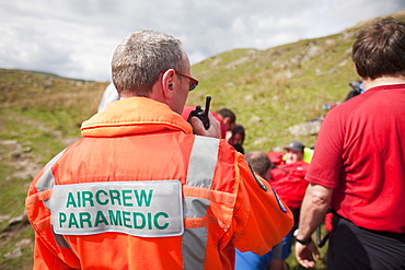 A man with a leg injury is treated by members of the Langdale Ambleside Mountain Rescue Team before being evacuated by air ambulance, above Grasmere, Lake District, Cumbria, England, United Kingdom, Europe