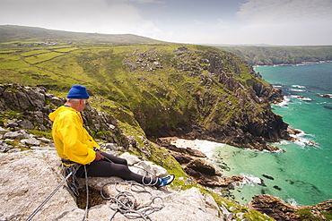 A couple in their 70s climbing on a granite sea cliff at Bosigran on the Cornish coast, Cornwall, England, United Kingdom, Europe