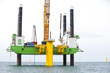 The jack up barge that hammers the monopiles into the sea bed fits a transition piece onto the top of the monopile, Walney Offshore Wind Farm, Cumbria, England, United Kingdom, Europe