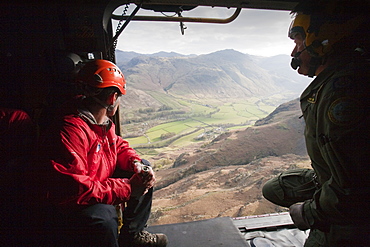 Member of Langdale Ambleside Mountain Rescue team and an RAF winch man in an RAF Sea King helicopter during a rescue in Dungeon Ghyll in the Langdale Pikes Lake District, Cumbria, England, United Kingdom, Europe