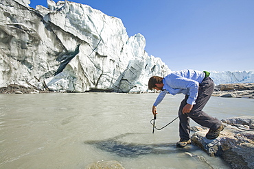 PHD scientist Ian Bartholomew taking measurements as part of a study to measure the speed of the Russell Glacier near Kangerlussuaq, Greenland, Polar Regions