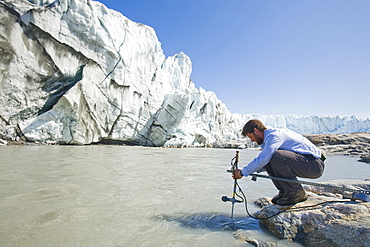 PHD scientist Ian Bartholomew taking measurements as part of a study to measure the speed of the Russell Glacier near Kangerlussuaq, Greenland, Polar Regions