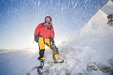 Climber being blasted by spindrift during high winds moving snow above Grasmere in the Lake District, Cumbria, England, United Kingdom, Europe