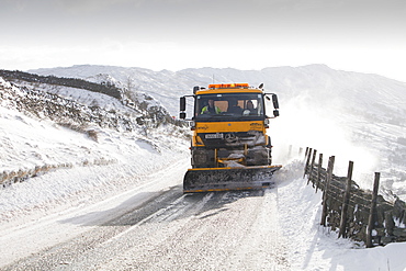 A council snow plough salting and trying to clear Kirkstone Pass in severe winter weather, November 201 Lake District, Cumbria, England, United Kingdom, Europe