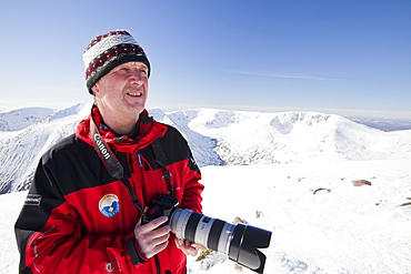 A mountaineer looking towards the Angels Peak and Braeriach across the Lairig Ghru from the summit of Ben Macdui, Cairngorm mountains, Scotland, United Kingdom, Europe