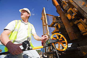 A workman measures the depth of the borehole at a geothermal energy project by Newcastle University, funded by the Department of Energy and Climate Change, Newcastle, Tyne and Wear, England, United Kingdom, Europe