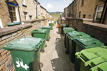 Rubbish bins on a back alley between terraced houses in Saltaire, Yorkshire, England, United Kingdom, Europe