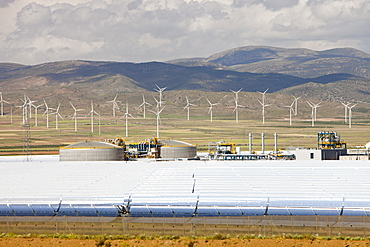 The Andasol solar power station near Guadix with a wind farm in the background, Andalucia, Spain, Europe