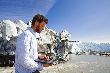 PhD scientist Ian Bartholomew taking measurements as part of a study to measure the speed of the Russell Glacier near Kangerlussuaq, Greenland, Polar Regions