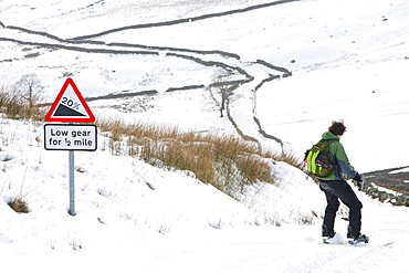 A man snow boarding down from the summit of Kirkstone Pass in the Lake District, Cumbria, England, United Kingdom, Europe