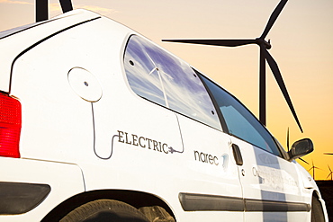 An electric car at dawn over Whitlee wind farm on Eaglesham Moor just south of Glasgow in Scotland, United Kingdom, Europe