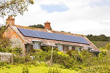 Solar panels on an old house on the Dorset coast near Charmouth, Dorset, England, United Kingdom, Europe