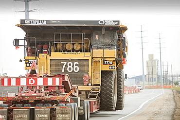 Truck hauls an oversize load, a massive dump truck used in the tar sands mines, on the road towards Fort McMurray, the centre of the tar sands industry, Alberta, Canada, North America