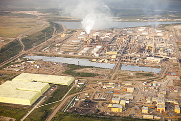 Sulphur which has to be extracted from the raw bitumen from tar sands piled up in huge mountains by the Syncrude upgrader plant near Fort McMurray, Alberta, Canada, North America