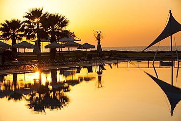 A holiday complex swimming pool at sunset in Myrina on Lemnos, Greek Islands, Greece, Europe