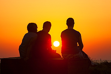 People relaxing by the sea at sunset at a holiday complex in Myrina on Lemnos, Greek Islands, Greece, Europe