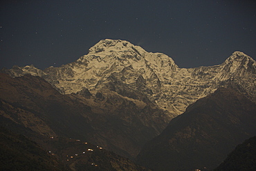 Lights of a small village being powered by a micro hydro plant below Annapurna South, Himalayas, Nepal, Asia