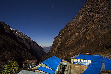 The night sky over a peak in the Annapurna Sanctuary, with a tea house int he foreground, Himalayas, Nepal, Asia