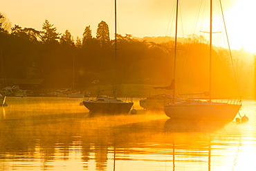 Sailing boats on Lake Windermere at sunrise with will o wisp mist, Waterhead, Ambleside, Lake District National Park, Cumbria, England, United Kingdom, Europe