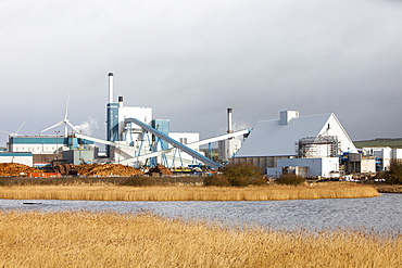 The new biofuel power plant at the Iggesund paper board manufacturer, with wind turbines behind, Workington, Cumbria, England, United Kingdom, Europe